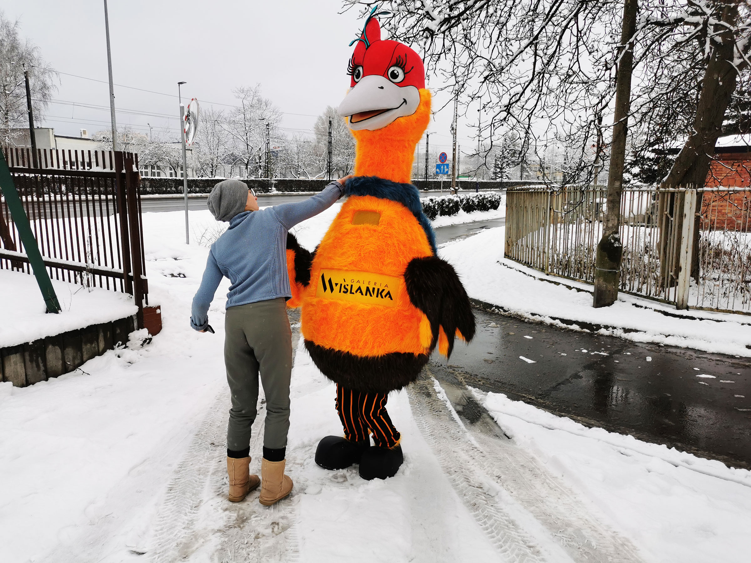 Na fotografii widnieje przebranie za postać feniksa pozujące do zdjęcia przed siedzibą firmy Elabika